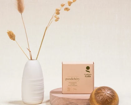 Shampoing Solide Ayurvédique Pondichéry certifié Bio 70g avec son emballage posé sur un socle en bois, ambiance naturelle