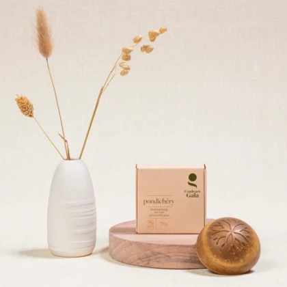 Shampoing Solide Ayurvédique Pondichéry certifié Bio 70g avec son emballage posé sur un socle en bois, ambiance naturelle