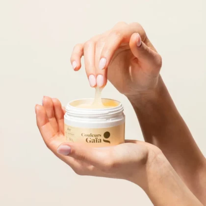 Pot Aloe Gel coiffant certifié bio 80g, posé sur une main. L'autre main retire ses doigts du pot afin de montrer la texture du gel coiffant.