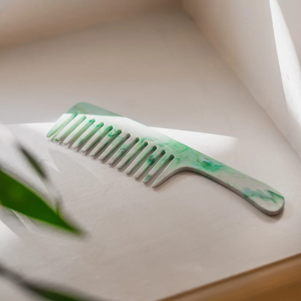 Ambiance naturelle, le peigne Couleurs Gaïa est posé sur le rebords d'une salle de bain